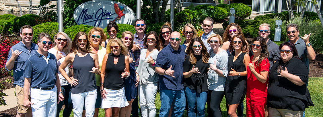 Photo of Corporate Gifts Team in front of Maui Jim sign